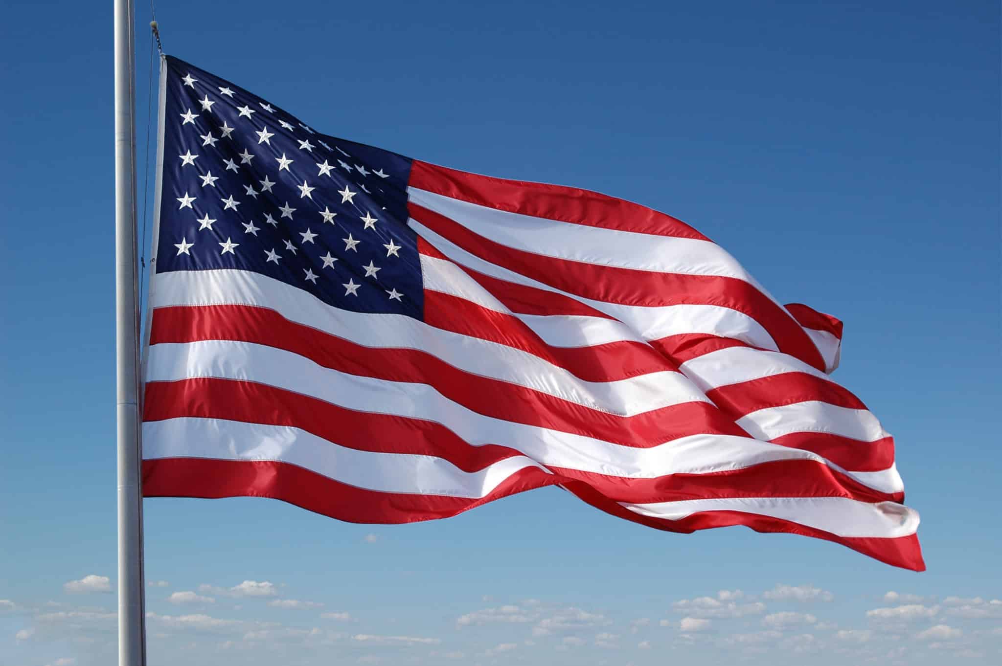 American flag flying with blue sky
