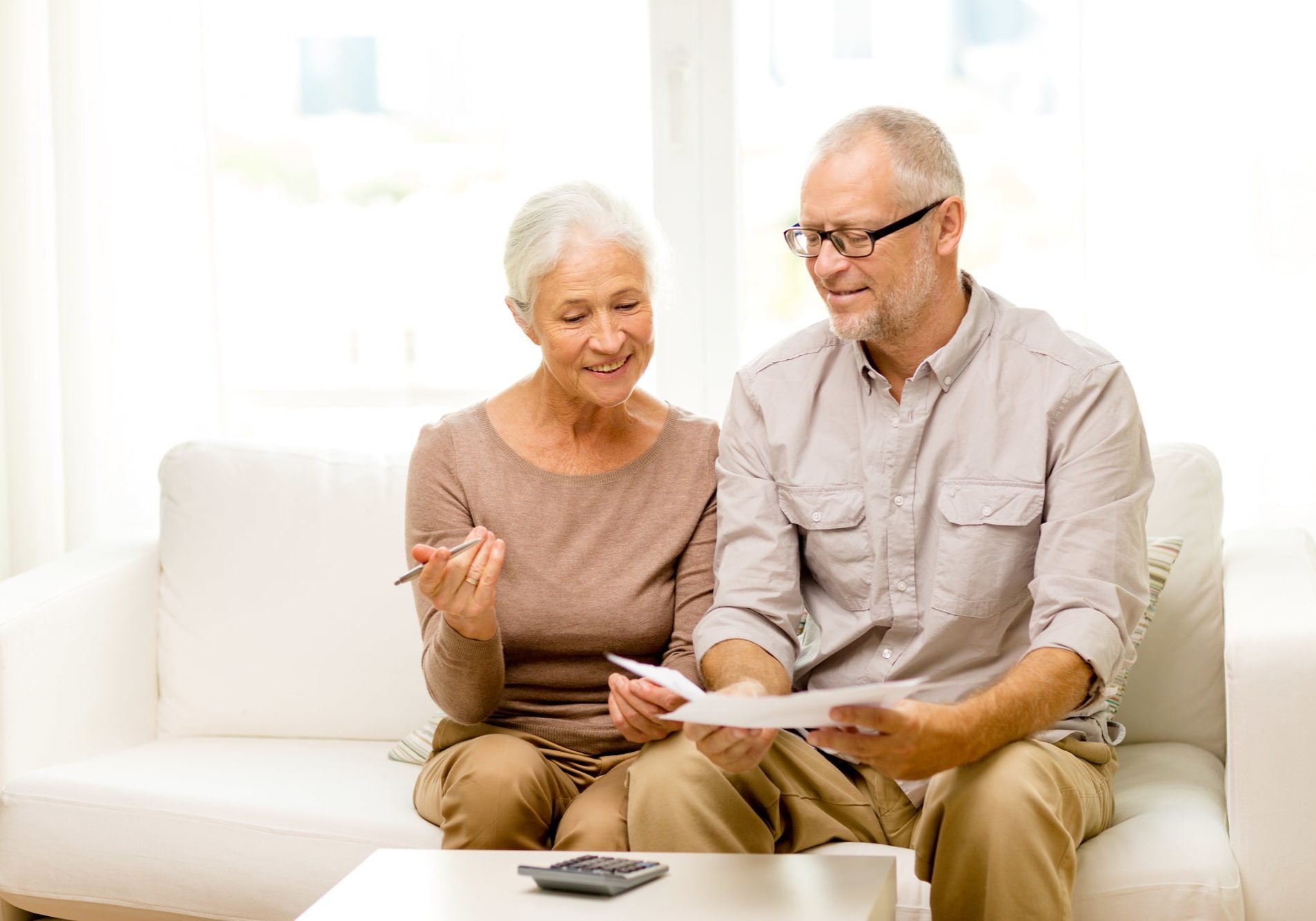 family, business, savings, age and people concept - smiling senior couple with papers and calculator at home